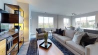 Located at 101 Avenue of the Arts in Wilmington, Delaware, this contemporary single-floor residence showcases a thoughtfully designed interior with modern finishes throughout. Light-toned hardwood flooring flows seamlessly across the living areas, complementing the neutral gray palette of the walls and creating a cohesive, airy aesthetic.

The open-concept living room is bathed in natural light from expansive windows and features direct access to a private balcony offering urban views. The space flows into a well-appointed kitchen equipped with dark espresso cabinetry, white quartz countertops, a herringbone tile backsplash, stainless steel appliances including a gas range, and a large center island with bar seating — ideal for entertaining.

The bedrooms offer a calm retreat, each featuring the same light hardwood flooring, generous natural light, and clean architectural lines. One bedroom provides direct balcony access through sliding glass doors, framing scenic city and waterfront views. The bathrooms are finished with large-format tile, dark accent tile surrounds, and clean white fixtures, including both a shower and a bathtub option.

Throughout the residence, the design balances contemporary style with functional living, offering a polished urban home in the heart of Wilmington's arts district.