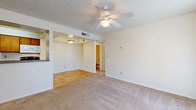 Located at 4101 W Union Hills Dr in Phoenix, AZ, this single-floor residence offers a practical and well-organized layout with two bedrooms, two bathrooms, and two closets. The open living and dining area features neutral-toned carpet, a ceiling fan with light fixture, and a textured ceiling, creating a clean and comfortable atmosphere. A sliding glass door dressed with vertical blinds fills the space with natural light and provides outdoor access. The galley-style kitchen is efficiently arranged with warm wood cabinetry, light hardwood-style flooring, a full suite of black appliances including a refrigerator, range, dishwasher, and built-in microwave, along with a utility sink and ample counter space. Both bathrooms are finished with hardwood-style flooring, granite-topped vanities, and full tub-shower combinations. The primary bedroom offers a generous footprint with carpeted floors, a ceiling fan, vertical blinds over a sliding glass door, and a dedicated closet. The second bedroom is similarly carpeted with a windowed wall and its own closet. Neutral wall tones and consistent finishes throughout lend the space a cohesive, move-in-ready character ideal for comfortable everyday living in the Phoenix area.