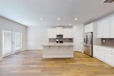 Located at 110 Cardinal George Ct in Easley, SC, this well-appointed two-story home offers four bedrooms and four bathrooms across two floors. The main level features an open-concept kitchen and living area finished with light hardwood-style flooring and recessed lighting. The kitchen is a standout, showcasing white shaker cabinetry, granite countertops, a central island with seating, a gray subway tile backsplash, and stainless steel appliances. An attached garage with a concrete floor and electrical panel provides practical utility. The staircase connecting both floors features warm wood treads, white risers, and an elegant railing with wood newel posts and decorative wrought iron balusters. Upstairs, the spacious primary bedroom includes a tray ceiling, ceiling fan, and a walk-in closet with wire shelving. Additional bedrooms are well-sized, featuring ceiling fans and natural light. The bathrooms are outfitted with granite-topped white vanities and hardwood-style flooring. A dedicated laundry room with washer and dryer hookups adds convenience. Throughout, neutral tones, clean lines, and consistent finishes create a bright, cohesive atmosphere suited for comfortable everyday living.