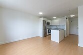 This 280 square foot apartment, located at 426 Central Ave in London, Ontario, offers a thoughtfully designed single-floor living space. The modern kitchen is a standout feature, boasting sleek white cabinetry that extends to the ceiling, maximizing storage. Stainless steel appliances, including a full-sized refrigerator, built-in microwave, and electric range, add a contemporary touch. A central island with a grey countertop provides additional workspace and separates the kitchen from the living area.

The main living space is bright and airy, thanks to large windows that allow natural light to flood the room. Light wood flooring runs throughout, creating a sense of continuity and openness. A baseboard heater along the exterior wall ensures comfort during colder months.

The bathroom, while compact, is efficiently designed with a full-sized bathtub and shower combination. White tiles and fixtures contribute to a clean, crisp aesthetic. The apartment's layout makes excellent use of the available 280 square feet, creating a functional and comfortable living environment. Despite its modest size, this apartment offers all the essentials for modern urban living in a well-organized, attractive package.