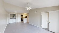 Located at 15550 Knoll Trail Dr in Dallas, TX, this single-floor residence offers a practical and comfortable layout across two bedrooms and two full bathrooms. The kitchen is a standout feature, designed with white cabinetry, light stone-patterned countertops, and a peninsula with a built-in sink that opens toward the living area. Black appliances, including a refrigerator, range, and dishwasher, provide a clean contrast to the bright white finishes, while light-toned flooring and overhead lighting complete the functional workspace. A stackable washer and dryer unit is conveniently tucked within the kitchen area. The bedrooms are carpeted and finished in warm neutral tones, with the primary bedroom offering generous proportions, a ceiling fan with light fixture, large windows that bring in natural light and outdoor views, and access to multiple closets. The second bedroom also features carpet, natural light from a window, and a textured ceiling. Both bathrooms are finished in crisp white, with one featuring a tiled tub-shower combination, and the other offering a vanity with stone-patterned countertop and a large mirror with overhead lighting. Hallways connect the spaces efficiently throughout, creating a cohesive and well-organized floor plan.