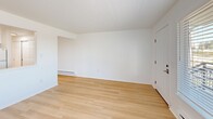 Located at 3302 Pacific Ave in Tacoma, Washington, this one-bedroom, one-bathroom unit offers a well-designed, single-floor layout that makes efficient use of its cozy footprint. The interior is finished with light wood-tone flooring throughout, creating a warm, cohesive aesthetic across all rooms.

The kitchen is a standout feature, outfitted with crisp white shaker-style cabinetry extending to the ceiling, light stone-look countertops, a stainless steel sink, and white appliances including a freestanding range and full-size refrigerator. The layout provides ample counter and storage space, making the kitchen both functional and visually clean.

The combined living area is bright and open, anchored by a large picture window that fills the space with natural light and offers views of the surrounding neighborhood. A baseboard heating system runs along the walls, ensuring year-round comfort.

The bedroom is a comfortable size, featuring double sliding closets that provide generous storage, a baseboard heater, and a window that brings in additional natural light. The bathroom includes a full soaking tub with a shower and a clean, all-white surround. Throughout the unit, white walls and neutral finishes create a fresh, move-in-ready atmosphere that is both practical and inviting.