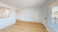 Located at 3302 Pacific Ave in Tacoma, Washington, this one-bedroom, one-bathroom unit offers a well-designed, single-floor layout that makes efficient use of its cozy footprint. The interior is finished with light wood-tone flooring throughout, creating a warm, cohesive aesthetic across all rooms.

The kitchen is a standout feature, outfitted with crisp white shaker-style cabinetry extending to the ceiling, light stone-look countertops, a stainless steel sink, and white appliances including a freestanding range and full-size refrigerator. The layout provides ample counter and storage space, making the kitchen both functional and visually clean.

The combined living area is bright and open, anchored by a large picture window that fills the space with natural light and offers views of the surrounding neighborhood. A baseboard heating system runs along the walls, ensuring year-round comfort.

The bedroom is a comfortable size, featuring double sliding closets that provide generous storage, a baseboard heater, and a window that brings in additional natural light. The bathroom includes a full soaking tub with a shower and a clean, all-white surround. Throughout the unit, white walls and neutral finishes create a fresh, move-in-ready atmosphere that is both practical and inviting.