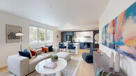 Located at 3260 SE Milwaukie Ave in Portland, OR, this two-bedroom, one-bathroom home offers a thoughtfully designed single-level layout with modern finishes throughout. The open-concept living and kitchen area serves as the heart of the home, featuring light-toned hardwood-style flooring, crisp white walls, and large windows that flood the space with natural light and frame views of the surrounding neighborhood greenery. The kitchen is outfitted with a striking two-tone design — navy lower cabinetry paired with white upper cabinets — complemented by a classic white subway tile backsplash, a central island with bar seating, and stainless and black appliances including a gas range and French door refrigerator. A bold navy accent wall adds a dramatic architectural focal point to the space. The living area is generous and bright, with multiple windows providing cross-ventilation and natural light. Both bedrooms are well-proportioned with light neutral walls, hardwood-style flooring, and good closet storage, with the primary bedroom offering a comfortable retreat. The full bathroom features a tub-shower combo with vertical white tile, matte black fixtures, a navy vanity, and a frameless mirror, maintaining the home's cohesive modern aesthetic throughout.