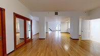 Located at 541 S Broadway in the heart of Downtown Los Angeles, this single-floor unit offers a generous and well-appointed layout comprising a combined kitchen and living area, a full bathroom, and a closet. The expansive open-plan living area is characterized by warm hardwood flooring, crisp white walls, and abundant natural light streaming through striking arched windows that lend a distinctive architectural character to the space. The layout flows openly across the main living zone, providing a versatile floor plan suited to a variety of configurations. The kitchen is efficiently designed with light wood cabinetry featuring glass-panel upper doors, granite-style countertops, tile flooring, and a full suite of stainless steel appliances including a range, microwave, and refrigerator. The bathroom is finished with tile flooring and includes a combined shower and bathtub with a sliding glass enclosure. A dedicated closet provides practical storage. Throughout the space, warm wood baseboards complement the hardwood floors, and the overall aesthetic balances a clean, modern sensibility with classic architectural details — most notably the elegant arched windows that anchor the living area and connect the interior to the vibrant surroundings of Downtown Los Angeles.