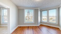 Located at 500 Euclid in Lynchburg, VA, this cozy yet well-appointed one-bedroom, one-bathroom residence offers a thoughtfully designed layout across a single floor. Warm hardwood-style flooring flows throughout the living areas and bedroom, complemented by soft gray walls and crisp white trim that give the space a clean, inviting feel.

The living room is bathed in natural light from multiple windows that frame pleasant neighborhood views, and features a textured ceiling that adds a touch of character. A wall-mounted mini-split unit ensures year-round climate comfort in the living area.

The kitchen is efficiently laid out with white cabinetry, dark stone-look countertops, a stainless-under-hood range, and a full-size refrigerator. Light ceramic tile flooring and generous windows keep the space bright and functional. A direct exterior entry door adds everyday convenience.

The bedroom is generously sized, offering ample natural light through multiple windows and a wall-mounted mini-split unit for personalized climate control. A stacked washer and dryer unit is conveniently located within the bedroom, alongside closet storage.

The bathroom is a standout feature, showcasing large-format marble-look tile surrounding a soaking tub, creating an elegant and serene retreat. Overall, this residence blends practical amenities with tasteful finishes in a compact, efficient footprint.