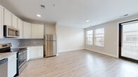 Located at 80 S 18th St. in Columbus, OH, this 2-bedroom, 1-bathroom unit offers a thoughtfully designed single-floor layout with modern finishes. The open-concept living and kitchen area is anchored by light hardwood-style flooring that flows throughout the main spaces, creating a bright and cohesive feel. Natural light pours in through multiple windows, enhancing the airy, neutral color palette of soft whites and warm beiges.

The well-appointed kitchen is a standout feature, boasting white shaker-style cabinetry, granite countertops, a subway tile backsplash, and a full suite of stainless steel appliances including a refrigerator, range, microwave, and dishwasher. A pendant light adds a modern touch above the workspace. The kitchen opens seamlessly into the living area, which includes a glazed door providing additional access and natural light.

Both bedrooms feature plush carpeting and are finished with clean, neutral walls. The primary bedroom connects to a dedicated closet outfitted with wire shelving systems for ample storage. The bathroom is well-proportioned, featuring granite countertops, an undermount sink, and wood-look tile flooring that complements the rest of the unit. The overall design is clean, contemporary, and move-in ready.