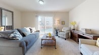 This three-floor home in Ypsilanti, Michigan offers a thoughtfully arranged layout with 3 bedrooms and 2.5 bathrooms. The main living area features plush carpeting and a sliding glass door that opens to a private balcony, filling the space with natural light and outdoor views. Adjacent to the living room, the dining area showcases light hardwood-style flooring, an elegant arched entryway, and a chandelier overhead, creating a warm and inviting atmosphere. The galley-style kitchen is well-equipped with honey-toned cabinetry, granite-style countertops, black appliances including a gas range and dishwasher, and a window that brings in natural light. The bedrooms offer comfortable carpeted floors, with the primary bedroom featuring vaulted ceilings, multiple closets, and generous natural light from multiple windows. The full bathrooms include tiled flooring, granite-topped vanities, and tub-shower combinations, while a convenient half bath rounds out the layout. A dedicated in-unit laundry area houses a full-sized washer and dryer. Neutral tones throughout the home create a cohesive and versatile aesthetic, making this a well-appointed and functional residence.