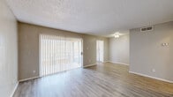 Located at 5208 11th St in Lubbock, TX, this one-bedroom, one-bathroom unit offers a well-organized layout across a single floor. Light wood-style flooring runs throughout, complemented by neutral beige walls and textured ceilings that give the space a clean, consistent aesthetic.

The combined living and dining area serves as the heart of the unit, featuring a large sliding glass door dressed with vertical blinds that floods the space with natural light and provides access to an outdoor area. The open sightlines into the kitchen make the layout feel connected and functional.

The kitchen is equipped with white cabinetry, a coil-burner electric range, refrigerator, and ample counter space — all finished in a cohesive white palette that keeps the area feeling bright and tidy.

The bedroom is a generously sized retreat featuring a ceiling fan, a window with natural light, light wood-style flooring, and a dedicated closet with built-in shelving for organized storage. Two closets are available throughout the unit, offering practical storage solutions.

The full bathroom includes a tub/shower combination with tile surround, a white vanity with a stone-look countertop, and wood-style flooring that ties in with the rest of the unit. The overall ambiance is clean, neutral, and move-in ready.