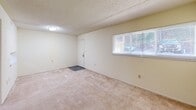 Located at 220 Brown West Dr in Rockwood, TN, this single-floor residence offers three bedrooms, one bathroom, a kitchen, a hallway, and a closet within a compact and efficiently arranged floor plan. The layout, visible in the dollhouse view, organizes living spaces in a straightforward, functional manner. Throughout the home, neutral-toned carpet and light-colored walls create a clean, consistent aesthetic. Textured ceilings are found throughout, adding a classic residential character to each room. The spacious primary bedroom features a large sliding glass door with vertical blinds that opens to an outdoor area, allowing natural light and outdoor views to fill the room. A ceiling fan with integrated lighting adds comfort to this space. The additional bedrooms are carpeted and well-proportioned, each with access to closet space and natural light through windows with blinds. The kitchen is equipped with wood-toned cabinetry and a double stainless steel sink set into light-colored countertops, providing practical workspace. The bathroom includes a full tub-shower combination with a curtain. A connecting hallway ties the rooms together, completing this straightforward and functional residential layout.