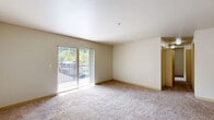 Located in Mill Creek, WA, this three-bedroom, two-bathroom residence is thoughtfully laid out across a single floor, making efficient use of its space. The living room serves as the heart of the home, featuring plush carpeting, neutral cream-toned walls, and a textured ceiling. Large sliding glass doors lead to a private balcony that brings in generous natural light and views of the surrounding greenery, creating a bright and welcoming atmosphere.

The kitchen is equipped with light wood cabinetry, stone-toned countertops, and wood-look flooring, providing a clean and functional workspace. The two bathrooms continue the warm, neutral palette, with one featuring a wide vanity with extended countertop space, light wood cabinetry, a large mirror, and wood-look flooring, while the second includes a full soaking tub and shower combination.

The three bedrooms are carpeted and offer a calm, comfortable feel. The primary bedroom is generously sized, while the additional bedrooms provide flexible space for various needs. At least one bedroom features a walk-in closet with built-in rod storage. A hallway connects the private areas of the home, and two closets offer additional storage throughout the unit. Overall, the space presents a clean, functional, and comfortable living environment.