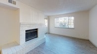 Located at 5109 S Delaware St in Englewood, Colorado, this single-floor residence offers a well-organized layout with a range of practical and inviting features throughout. The living area serves as the focal point of the home, highlighted by a striking white brick fireplace with a glass-front surround and a raised hearth. Large windows and a sliding glass door flood the space with natural light while providing views of the surrounding outdoor area. Durable hardwood-style flooring runs through the main living and kitchen areas, creating a cohesive and easy-to-maintain surface.

The kitchen is equipped with stainless steel appliances, including a range, built-in microwave, and dishwasher, all complemented by gray cabinetry, white countertops, and a stainless steel sink. The open pass-through layout connects the kitchen to the living and dining areas, supporting an efficient flow throughout the home.

Bedrooms feature plush carpeting and receive natural light through well-placed windows. One bedroom includes a sliding glass door for additional outdoor access. The bathrooms are finished in a clean, bright palette, each offering a full tub-shower combination, white vanity, and hardwood-style flooring. Textured ceilings are consistent throughout the home, adding a classic residential character to every room.