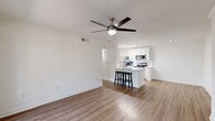 Located at 3720 W Alabama St in Houston's desirable Galleria neighborhood, this 2-bedroom, 1-bathroom residence offers a clean, modern aesthetic across a single thoughtfully arranged floor. Light wood-look flooring flows consistently throughout, creating a cohesive and warm atmosphere from room to room.

The galley-style kitchen is a standout feature, outfitted with white shaker cabinetry, quartz countertops, white subway tile backsplash, and a full suite of stainless steel appliances including a refrigerator, electric range, over-the-range microwave, and dishwasher. A skylight panel overhead adds brightness to the efficient layout.

The open living area benefits from crown molding and a ceiling fan, with a sliding glass door leading to a private balcony that brings in natural light and outdoor views. Both bedrooms are comfortably sized, each equipped with ceiling fans and large windows that allow ample natural light — the primary bedroom offering a generous footprint. A dedicated closet provides additional storage.

The bathroom features a tub-shower combination, a wide vanity with white cabinetry, a large mirror, and warm wood-look flooring that ties in with the rest of the home. A hallway connects all areas with ease, completing this clean and functional layout.