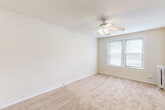 Located at 4606 N Hermitage Ave in Chicago's Ravenswood neighborhood, this one-bedroom, one-bathroom unit offers an efficient and well-organized layout across a single floor. The generously sized bedroom is the heart of the unit, featuring soft neutral carpet, bright white walls, and a ceiling fan with integrated lighting. A wide window allows natural light to fill the room, creating a warm and airy atmosphere. The bedroom provides direct access to a dedicated closet, while two additional closets throughout the unit offer exceptional storage capacity — a rare find in a space of this scale. The compact kitchen is thoughtfully designed with white cabinetry, a warm wood-toned countertop, a white tile backsplash, and durable hardwood-style flooring. It is equipped with a full-size refrigerator, gas range, and stainless steel sink. The bathroom retains a classic character with white herringbone tile flooring, full-surround wall tile, a soaking tub with shower, a pedestal-style vanity, and a vintage cast-iron radiator beneath a natural light-admitting window. Clean white trim and neutral tones throughout the unit create a cohesive, move-in-ready aesthetic that is both functional and inviting.