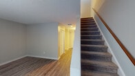 This two-story space is thoughtfully laid out across two distinct levels connected by a carpeted staircase with a wooden handrail. The main level features durable wood-look plank flooring throughout its open living areas, complemented by neutral gray walls and textured ceilings. A well-appointed kitchen showcases gray cabinetry, white subway tile backsplash, light stone countertops, and stainless steel appliances including a refrigerator, range, and built-in microwave. A half bathroom on this level includes a dark-cabinetry vanity with white countertop, brushed nickel fixtures, and a framed mirror with modern lighting. The lower level also includes a versatile room with a louvered closet and direct access to additional storage beneath the staircase.

Upstairs, plush carpeting extends through the bedrooms, each offering neutral tones and ample natural light via window treatments. One carpeted bedroom features a large window with outdoor views, while another room benefits from generous wall space and a standard closet. A full bathroom on this level includes a tub-shower combination with tiled surround, a single-sink vanity with dark cabinetry, and brushed nickel hardware throughout. The overall ambiance is clean, neutral, and move-in ready.