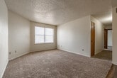 Located at 1010 North 1st Street in Jacksonville, Arkansas, this single-floor, 3-bedroom, 1-bathroom home offers a practical and comfortable layout. The living room is bright and welcoming, featuring plush carpet flooring, neutral cream-toned walls, and a textured ceiling that carries throughout much of the home. Natural light filters in through blinded windows, creating an airy atmosphere.

The galley-style kitchen is efficiently designed with warm wood-toned cabinetry lining both sides, white appliances including a coil-top electric range, dishwasher, and refrigerator, along with a stainless steel sink and light countertops. Wood-look vinyl flooring adds durability and a clean aesthetic to the kitchen space.

The three bedrooms are carpeted and well-proportioned, each featuring neutral walls and textured ceilings. The primary bedroom is generously sized and includes natural light from a window. Several bedrooms include closet storage, with one featuring a classic double wood sliding closet door.

The full bathroom is neatly appointed with wood-look flooring, a white vanity with a marble-style countertop, and a tub/shower combination with a grab bar and curtain rod. A hallway and dedicated closet round out the floor plan, contributing to an organized and functional living experience throughout the home.