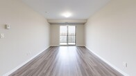 This well-appointed 2-bedroom, 2-bathroom unit at 220 Ira Needles Blvd in Kitchener, Ontario offers a thoughtfully designed layout across a generous single floor. The entrance leads into a bright, open-concept living and dining area finished with light-toned laminate hardwood flooring that flows throughout the main living spaces. Large sliding glass doors and expansive windows fill the area with natural light and provide direct access to a private balcony with outdoor views.

The kitchen features white cabinetry, a subway tile backsplash, and stainless steel appliances, including a full-size refrigerator, with light tile flooring tying the space together. The spacious primary bedroom offers room for a full furniture arrangement, complemented by a dedicated walk-in closet with wire shelving for efficient storage. The second bedroom is equally comfortable and well-lit, with its own closet access.

Both bathrooms are finished in neutral tones, with one featuring a full soaker tub and shower combination, a white vanity, and tile flooring. A dedicated in-unit laundry room houses a full-size washer and dryer, adding everyday convenience. Three closets throughout the unit provide generous storage. The overall aesthetic is clean, modern, and move-in ready.