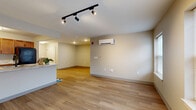 Located at 700 Broad Leaf Path in Mechanicville, NY, this single-floor, 2-bedroom, 1-bathroom residence offers a clean, modern design with consistent wood-look flooring throughout. The open-concept living area is bright and spacious, featuring track lighting, a wall-mounted mini-split HVAC system for efficient climate control, and multiple windows that bring in natural light. The kitchen is well-equipped with warm wood cabinetry, marble-style countertops, a stainless steel sink, and full appliances including a refrigerator and range. A peninsula counter connects the kitchen to the living area, creating a functional and social layout. The primary bedroom is generously sized, offering ample space and access to the shared hallway. The second bedroom includes a window for natural light and features two white panel closet doors, providing excellent storage. The full bathroom is finished with large-format tile flooring, a wood vanity with white countertop, a wall-mounted mirror, and a lighted vanity fixture, giving it a clean and polished look. Throughout the residence, neutral tones, white trim, and consistent finishes create a cohesive and modern atmosphere well-suited for comfortable everyday living.