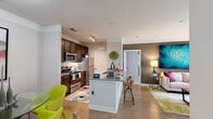 This single-floor residence in Yorktown, Virginia offers a thoughtfully designed open-concept layout that seamlessly connects the kitchen, dining, and living areas. The kitchen is outfitted with stainless steel appliances, including a refrigerator, range, and microwave, complemented by rich dark cabinetry, granite-style countertops, a white subway tile backsplash, and a peninsula with bar seating. Light wood-style flooring runs throughout the main living areas, enhancing the bright, airy atmosphere.

The living room is generously sized, featuring large sliding glass doors that open to a private balcony and allow abundant natural light. Crown molding and neutral wall tones provide a clean backdrop for the space.

The residence includes multiple bedrooms, each carpeted and filled with natural light from large windows. One bedroom features a bold teal accent wall, while another is finished in soft, neutral tones. Both offer ample space and closet access.

The bathrooms are well-appointed with wood-toned vanity cabinetry, white countertops, and tub-shower combinations. A dedicated in-unit laundry area provides a side-by-side washer and dryer with built-in wire shelving for additional storage, adding a practical and convenient feature to the overall layout.