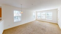 Located at 850 Crouchen St NW in Salem, Oregon, this single-floor unit offers a functional and well-organized layout. The open-concept living and dining area is generously sized, featuring wall-to-wall carpet, multiple windows that admit abundant natural light, and a pendant light fixture over the dining space. Views of the surrounding neighborhood are visible through the large windows.

The kitchen is positioned adjacent to the living area and is separated by a partial wall with a breakfast bar. It features warm honey-toned cabinetry offering ample storage, light-colored countertops, tile flooring, and a full suite of white appliances including a refrigerator, electric range, built-in microwave, and dishwasher. A window above the sink provides additional natural light.

The bedrooms are carpeted and well-proportioned. One bedroom includes a ceiling fan, a sliding double-door closet, and a window with outdoor views. Another room features windows overlooking a balcony area.

The unit includes two bathrooms. The full bathroom is equipped with tile flooring, a tub-shower combination with sliding glass doors, a wood-toned vanity, and a large mirror with overhead lighting. A second bathroom provides a toilet and vanity. Throughout, the unit maintains a clean, neutral palette.