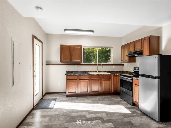 Kitchen features a stove and refrigerator - 10306 41st Trl SE