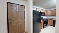 Located in Fargo, ND, this single-floor 3-bedroom, 2-bathroom unit offers a functional and well-organized layout suited for everyday living. The kitchen features warm honey-toned cabinetry, laminate flooring, granite-look countertops, and a full suite of black appliances including a refrigerator, range, microwave, and dishwasher. It opens conveniently toward the living room, which is carpeted and filled with natural light from a sliding glass door that leads to an outdoor area. The bedrooms are carpeted and neutral in tone, each providing a comfortable and quiet retreat. The primary bedroom includes closet space and baseboard heating. Additional bedrooms share similarly practical layouts. Both bathrooms are finished with tile flooring, vanity cabinetry, and tub-shower combinations. A dedicated laundry room with full-size washer and dryer and overhead shelving adds significant convenience. Throughout the unit, textured ceilings, wood-trimmed doors, and baseboard heating are consistent design elements. The overall ambiance is clean, practical, and move-in ready, making this a solid residential option in south Fargo.