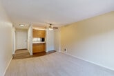 Located in Edmonds, WA, this 1-bedroom, 1-bathroom unit offers a well-organized layout designed to maximize comfort and functionality. The open-concept living room is bright and welcoming, featuring soft wall-to-wall carpeting, a ceiling fan with light fixture, and a sliding glass door that opens onto a private balcony with views of surrounding greenery. The galley-style kitchen is efficiently designed with warm wood cabinetry, granite-style countertops, hardwood-style flooring, and black appliances including a refrigerator, electric range, and dishwasher. A pass-through peninsula connects the kitchen to the living area, creating a natural flow between spaces. The spacious bedroom is carpeted and filled with natural light from a large window, and includes a sliding-door closet with hanging storage. A hallway connects the main living areas and leads to the full bathroom, which features a soaking tub with overhead shower, a vanity with granite-style countertops, and wood-style flooring. Throughout the unit, neutral tones and clean finishes create a calm, cohesive ambiance. Hardwood-style flooring in the entryway and kitchen transitions seamlessly to plush carpet in the living and sleeping areas, adding warmth and texture throughout.