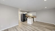 Located at 750 Bergen Rd in North Augusta, SC, this well-appointed 2-bedroom, 2-bathroom residence offers a thoughtfully designed single-floor layout. The open-concept living area seamlessly connects the living room, dining space, and kitchen, all unified by light wood-style luxury vinyl flooring that runs throughout the home and lends a clean, modern aesthetic.

The kitchen is a functional centerpiece, featuring crisp white cabinetry, granite-look countertops, a central island for additional prep space and seating, and black appliances including a refrigerator, range, microwave, and dishwasher. Recessed lighting illuminates the space efficiently.

Both bedrooms are generously sized with neutral gray walls, natural light from large windows, and the same consistent flooring. The spacious primary bedroom benefits from a sizeable walk-in closet outfitted with wire shelving for organized storage. In total, the home includes four closets, providing abundant storage throughout.

The two full bathrooms each feature a tub/shower combination, white vanity cabinetry, and marble-style tile flooring, offering a clean and functional design. A dedicated laundry area adds to the home's everyday convenience. The overall palette of soft grays and whites creates a bright, neutral atmosphere throughout this move-in-ready residence.
