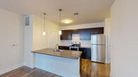 Located at 527 Old Bridge Tpke in East Brunswick, NJ, this well-appointed two-bedroom, two-bathroom residence offers a thoughtfully designed single-floor layout. The open-concept kitchen and living area serves as the heart of the home, showcasing rich dark cabinetry, granite countertops, a center island with a built-in sink, and stainless steel appliances including a refrigerator and range. Stylish pendant lighting illuminates the island, while hardwood-style flooring extends throughout the main living spaces, adding warmth and continuity.

The primary bedroom is a generously sized retreat filled with natural light from multiple windows with blinds, and features a spacious walk-in closet equipped with wire shelving for ample storage. The second bedroom also benefits from natural light and includes its own closet with built-in shelving. Both rooms are finished with plush carpeting for added comfort.

The two bathrooms are finished with clean, modern details. The primary bath features a glass-enclosed walk-in shower with white subway tile, tile flooring, and a window for natural light. The second bath includes a dark-cabinetry vanity with a granite countertop and tile flooring. A dedicated closet provides additional storage, completing this functional and attractively finished residence.