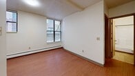 This 410 square foot apartment, located at 1401 Portland Ave in Minneapolis, offers a practical single-floor layout. The space consists of one bedroom, one bathroom, and a hallway, efficiently arranged to maximize the compact area. The primary bedroom, measuring 120 square feet, provides a comfortable sleeping area with a large window allowing natural light and outside views. The bathroom features a white tub-shower combination with built-in shelving and a towel bar for convenience. The apartment showcases a mix of flooring, with warm wood-like floors in some areas and carpeting in others, adding texture and warmth to the space. The walls are painted in neutral tones, creating a blank canvas for personalization. Large windows throughout the apartment offer ample natural light and ventilation. The kitchen area, while compact, appears functional with light-colored cabinetry. Overall, this apartment presents a practical and efficient living space, ideal for those seeking a cozy urban dwelling in Minneapolis.