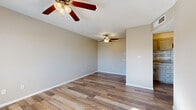 This single-story home offers a well-organized layout with consistent finishes throughout. The living areas are finished with warm wood-look plank flooring that runs seamlessly across the space, complemented by neutral beige and greige wall tones that create a bright, cohesive atmosphere. Textured ceilings add a classic touch, and ceiling fans are present in multiple rooms, providing both functionality and comfort year-round. The open living area is generously proportioned, with natural light filtering in through blinds-covered windows and ample room for a variety of furniture configurations. Multiple additional rooms serve well as bedrooms or flexible-use spaces, each featuring the same wood-look flooring, neutral walls, and individual ceiling fans or light fixtures. Windows with horizontal blinds allow for natural light while maintaining privacy. The bathroom is outfitted with a full tub-shower combination in a clean white surround, accompanied by standard fixtures in a simple, functional layout. White baseboards throughout add a crisp finish to each room. Overall, the home presents a clean, move-in-ready condition with a practical and versatile floor plan suited to a range of living arrangements.