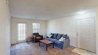 This single-story residence offers a well-organized layout encompassing three bedrooms, three bathrooms, and a dedicated closet for each bedroom. The living room serves as the central gathering space, featuring wall-to-wall carpeting, neutral-toned walls, and multiple windows that allow natural light to fill the room. A door provides direct exterior access, adding convenience to the living area.

The kitchen is designed for functionality, featuring white cabinetry, ample counter space, a double-basin sink, and a full suite of appliances including a range and microwave. The checkered tile flooring adds a classic touch to the space, and track lighting overhead ensures bright, practical illumination.

Each bedroom is carpeted and includes a window with blinds for natural light and privacy, along with its own closet for personal storage. The bedrooms maintain a clean, simple aesthetic with neutral walls and ceiling-mounted light fixtures. The primary bedroom offers a comfortable footprint suited for essential furnishings.

All three bathrooms follow a consistent, clean design with tiled shower-tub combinations, vanities with storage cabinetry, and tile flooring. The overall ambiance of the residence is straightforward and functional, with a consistent neutral color palette throughout that lends itself well to personalization.