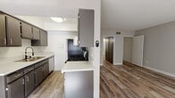 Located at 5425 Sepulveda Blvd in Los Angeles, CA, this single-floor unit offers a clean, modern interior with a thoughtfully designed open layout. The living area is bright and welcoming, featuring light-toned wood-style flooring, neutral gray walls, and a textured ceiling. Large windows along the front allow natural light to fill the space, and a ceiling fan adds comfort to the room.

The kitchen is efficiently laid out with dark gray cabinetry, light quartz-style countertops, and a full suite of appliances including a gas range, refrigerator, and dishwasher. A peninsula counter provides a natural partition between the kitchen and living area, enhancing the open-concept flow.

The bedroom is carpeted in a soft gray tone and includes a spacious sliding-door closet, offering generous storage. The textured ceiling and neutral wall color create a calm, restful atmosphere.

The bathroom is well-appointed with a quartz-topped vanity, a wide wall mirror, a single-basin sink, and a glass-door shower enclosure. Consistent finishes throughout the unit tie the design together cohesively.

Wood-style flooring extends through the main living and hallway areas, while the transition to carpet in the bedroom adds warmth. Overall, the unit presents a well-maintained, move-in-ready interior in a convenient Los Angeles location.