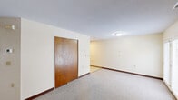 Located at 190 N Elm St in Manchester, CT, this single-floor unit offers a practical and straightforward layout across three bedrooms, one bathroom, and a dedicated kitchen. The spacious primary bedroom features a large closet with sliding wood-panel doors, neutral-toned carpet flooring, and a textured ceiling, providing a calm and functional living space. The two additional bedrooms are carpeted and bright, each featuring windows with blinds that allow natural light and views of the surrounding neighborhood. One of the secondary bedrooms includes its own closet. The kitchen is well-equipped with warm wood cabinetry, white appliances including a refrigerator, dishwasher, and electric range, and benefits from a skylight that adds brightness to the space. Vinyl flooring and ample counter space make it highly functional. The bathroom is clean and efficiently designed, featuring a walk-in shower with grab bars, a single-basin vanity, and a toilet, making it accessible and practical. Consistent neutral wall tones, dark wood baseboards, and carpeted floors throughout the living areas create a cohesive and understated aesthetic across the unit.