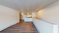 This single-floor residence offers a clean, modern layout designed for comfortable everyday living. The open-concept living and dining area is finished with warm hardwood-style flooring, neutral walls, and recessed lighting, creating a bright and welcoming atmosphere. Baseboard heating runs throughout the main living spaces, ensuring year-round comfort.

The kitchen is well-equipped and efficiently designed in a galley style, featuring white shaker cabinetry with brushed nickel hardware, light granite countertops, and a full suite of stainless steel appliances including a range, microwave, refrigerator, and dishwasher. A peninsula with a granite countertop connects the kitchen to the living area, providing additional prep and seating space.

Both bedrooms are carpeted and generously sized, each featuring a ceiling fan with light fixture and access to natural light through windows. The primary bathroom includes a walk-in shower, white vanity cabinetry with granite countertops, and hardwood-style flooring. The secondary bathroom mirrors this style and offers a full tub-shower combination.

A dedicated in-unit laundry room houses a full-size top-loading washer and dryer alongside wire shelving for storage, adding significant convenience to the layout.
