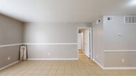 Located at 8600 S Course Dr in Houston, TX, this efficiently designed one-bedroom, one-bathroom unit offers a comfortable and functional layout across a single floor. Light-toned ceramic tile flooring runs throughout the space, lending a clean and cohesive look to each room.

The living area is bright and open, featuring neutral gray walls with a classic white chair rail accent, a large window with blinds that invites natural light, and a sliding glass door that opens to a private patio with outdoor views. A ceiling fan with an integrated light fixture adds both comfort and character to the room.

The kitchen is well-appointed with gray cabinetry, granite-style countertops, a decorative stone tile backsplash, and a full-size refrigerator. A built-in pantry cabinet provides additional storage, keeping the space organized and practical.

The bedroom is generously sized, echoing the same tile flooring and neutral palette found throughout, with a ceiling fan and a sliding glass door offering patio access and natural light. A dedicated closet provides ample storage.

The bathroom is clean and functional, featuring a full tub and shower combo with white tile surround, a toilet, and a vanity with overhead cabinetry. The overall ambiance of the unit is calm and understated, making it a practical and inviting home in southwest Houston.