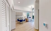 Located at 640 NW 7th Ave in Fort Lauderdale, FL, this thoughtfully designed one-bedroom, one-bathroom residence offers a clean, contemporary aesthetic throughout. The open-plan kitchen and living area serves as the heart of the home, featuring light hardwood flooring, soaring ceilings, and abundant natural light. The modern kitchen is equipped with stainless steel appliances — including a French door refrigerator, electric range, and over-the-range microwave — complemented by sleek taupe cabinetry and light quartz countertops. A dedicated dining area flows seamlessly into the living space, which opens via floor-to-ceiling sliding glass doors onto a private balcony overlooking lush tropical greenery. The bedroom is generously proportioned with tall ceilings, its own balcony access through large windows, and two closets for ample storage. The full bathroom features a soaking tub with a rainfall showerhead and large-format tile surround. Additional conveniences include an in-unit laundry area with a stacked washer and dryer tucked neatly behind louvered doors, plus a utility room. The residence combines practical functionality with a crisp, modern design sensibility.