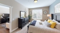 Located at 27000 W Lugonia Ave in Redlands, California, this single-story residence offers a thoughtfully designed layout with a comfortable, modern aesthetic throughout. The open-concept living and dining area features warm wood-look flooring, neutral-toned walls, and abundant natural light streaming through large windows and a glass door leading to a private balcony. The space flows seamlessly into a well-equipped kitchen outfitted with rich dark cabinetry, granite-style countertops, stainless steel appliances including a gas range and built-in microwave, and pendant lighting over a dining counter. The bedrooms are carpeted for comfort, each featuring generous windows with exterior views, neutral wall tones, and ample closet space with sliding doors. The primary bedroom includes direct balcony access via a glass door, enhancing the connection to the outdoors. The bathroom is well-appointed with dark wood cabinetry, a granite-topped vanity, and a full tub-shower combination. A dedicated in-unit laundry closet with stacked washer and dryer adds everyday convenience. Overall, the space presents a clean, contemporary feel with cohesive finishes and a functional, livable floor plan.