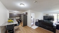Located at 135 Ward St in Revere, Massachusetts, this single-floor residence offers a thoughtfully designed layout that balances comfort and functionality. The open-concept living and dining area is anchored by light hardwood-style flooring, neutral walls, and a textured ceiling, creating a bright and welcoming atmosphere. A sliding glass door allows natural light to fill the living room, which also features a wall-mounted air conditioning unit and baseboard heating.

The kitchen is a standout feature, outfitted with rich dark cabinetry, granite-style countertops, a mosaic tile backsplash, and a full suite of stainless steel appliances including a refrigerator, electric range with hood, and dishwasher. A breakfast bar with seating provides a convenient dining option adjacent to the kitchen.

The unit includes two bedrooms, each carpeted and finished with neutral tones. The primary bedroom benefits from a sliding glass door opening to a balcony, offering outdoor views and additional natural light. The second bedroom features a standard window, providing a quiet and comfortable retreat.

The full bathroom is clean and functional, featuring light hardwood-style flooring, a dark vanity with a white countertop, and a shower-tub combination with a curtain enclosure.