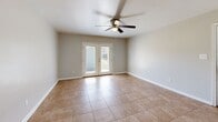Located at 2816 Eden St in Pascagoula, Mississippi, this single-story, 1-bedroom, 2-bathroom home offers a practical and cohesive layout with a clean, neutral aesthetic throughout. Warm beige tile flooring runs consistently across every room, creating a unified and easy-to-maintain interior. The combined kitchen and living area forms the heart of the home. The kitchen is a standout space, featuring bold teal cabinetry paired with granite countertops, black appliances including a range and dishwasher, a stainless steel refrigerator, and a breakfast bar that opens to the living area. The living room is bright and airy, highlighted by a ceiling fan and French doors that invite natural light and provide access to the outdoors. The bedroom is a comfortable size, equipped with its own ceiling fan and a dedicated closet. Both bathrooms continue the teal and granite theme, with one bathroom showcasing a tiled tub surround in a warm travertine-style pattern. A hallway connects the private areas of the home. Soft gray walls throughout complement the warm flooring and colorful cabinetry accents, giving the space a cohesive and inviting character.