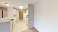 This single-floor residence at 4312 W 58th St in Sioux Falls, South Dakota offers a practical and well-organized layout across its living spaces. The open living area is generously sized, finished with neutral-toned carpet and a textured ceiling, and connects seamlessly to a galley-style kitchen. The kitchen features light wood cabinetry, a white appliance suite including a refrigerator, electric range, and microwave, along with tile flooring and a skylight-style overhead fixture that keeps the space well-lit.

The bedrooms are carpeted and finished in warm neutral tones, each receiving natural light through standard windows with blinds. One bedroom includes a standard reach-in closet, while another features a larger walk-in closet with a clothing rod. A sliding glass door in the living area provides access to an outdoor area and allows additional natural light.

Two bathrooms serve the unit. The primary bathroom includes a glass-door shower, a walk-in closet area, a vanity with storage cabinetry, and tile flooring. The secondary bathroom offers a full tub-shower combination, a toilet, and built-in cabinetry. A dedicated laundry room houses a full-size washer and dryer alongside wire shelving, completing the unit's functional amenities.