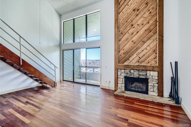 Living room with vaulted ceilings, high windows, balcony door, mountain views, and fireplace - 14282 E Tufts Pl