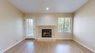 Located at 5121 Garfield Ave in Sacramento, CA, this well-appointed one-bedroom, one-bathroom residence offers a thoughtfully organized single-floor layout. The combined kitchen and living area serves as the heart of the home, featuring light wood-style flooring that flows throughout the space. Vaulted ceilings add a sense of openness to the living room, which is anchored by a tile-surround fireplace and a window that brings in natural light. A French-style door leads to a private balcony overlooking mature pine trees, providing a serene outdoor retreat. The kitchen is equipped with white shaker cabinetry, recessed lighting, a stainless sink, and black appliances including a full-size refrigerator and dishwasher. The spacious primary bedroom features vertical blinds over a sliding glass door and light wood flooring, complemented by a dedicated closet. A hallway connects the main living spaces to the bathroom, which offers a full tub-shower combination enclosed in glass sliding doors and wood-tone flooring. Warm neutral tones throughout the interior create a clean, cohesive aesthetic suited to comfortable everyday living.