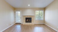 Located at 5121 Garfield Ave in Sacramento, CA, this well-appointed one-bedroom, one-bathroom residence offers a thoughtfully organized single-floor layout. The combined kitchen and living area serves as the heart of the home, featuring light wood-style flooring that flows throughout the space. Vaulted ceilings add a sense of openness to the living room, which is anchored by a tile-surround fireplace and a window that brings in natural light. A French-style door leads to a private balcony overlooking mature pine trees, providing a serene outdoor retreat. The kitchen is equipped with white shaker cabinetry, recessed lighting, a stainless sink, and black appliances including a full-size refrigerator and dishwasher. The spacious primary bedroom features vertical blinds over a sliding glass door and light wood flooring, complemented by a dedicated closet. A hallway connects the main living spaces to the bathroom, which offers a full tub-shower combination enclosed in glass sliding doors and wood-tone flooring. Warm neutral tones throughout the interior create a clean, cohesive aesthetic suited to comfortable everyday living.