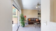 This single-floor, 2-bedroom, 2-bathroom home offers a thoughtfully designed layout that maximizes comfort and functionality. The living room serves as the heart of the home, featuring warm neutral tones, plush carpeting, a ceiling fan, and crown molding. Large sliding glass doors flood the space with natural light and open directly onto a private patio overlooking mature trees and landscaping, creating a seamless indoor-outdoor connection.

The kitchen is efficiently arranged in a U-shaped configuration, outfitted with warm wood cabinetry, granite-style countertops, tile flooring, and black appliances including a gas range, built-in microwave, dishwasher, and refrigerator. Adjacent to the kitchen, the dining area accommodates intimate gatherings and features a built-in corner shelving unit for added storage and display.

The primary bedroom is generously sized, offering carpeted floors, a large window with outdoor views, and ample room for furnishings. The second bedroom is equally comfortable, also carpeted and naturally lit through wide windows with vertical blinds. Both bathrooms are finished with tile flooring, tile-surround tub-shower combinations, wood vanity cabinetry, and wide mirrors. A hallway and closet complete the layout, contributing to practical day-to-day storage throughout the home.