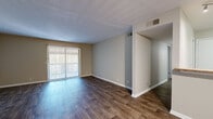 Located at 6700 Cabot Dr in Nashville, Tennessee, this single-floor residence offers a practical and well-organized layout with a clean, neutral aesthetic throughout. The open living area is a standout feature, showcasing rich wood-style flooring that extends through the main living and dining spaces. A large sliding glass door fitted with vertical blinds floods the living room with natural light while providing direct outdoor access, creating a bright and inviting atmosphere.

The kitchen is connected to the main living area via a convenient pass-through counter with a wood-toned ledge, allowing for easy interaction between spaces. Track lighting in the kitchen adds a functional, modern touch, and the room is equipped with a full-size refrigerator.

The bedrooms are carpeted for comfort and warmth, each featuring neutral-toned walls and windows with slatted blinds that allow for natural light. At least one bedroom includes a built-in closet with a hanging rod for storage. The bathroom is finished with wood-style flooring, a tiled soaking tub and shower combination, a granite-topped vanity with dark-framed storage drawers, and a wall-mounted mirror. The overall design is understated and move-in ready, offering a functional living environment in a convenient Nashville location.