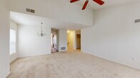 Located at Merchant's Square in Lancaster, PA, this well-designed 3-bedroom, 2-bathroom home offers a comfortable and functional layout across a single floor. The living room is a standout space, boasting soaring vaulted ceilings, a ceiling fan, and a classic chandelier that adds a touch of elegance. Plush neutral carpeting runs throughout the living areas and bedrooms, complementing the bright, airy atmosphere created by natural light filtering through window blinds. The kitchen features warm cherry-toned cabinetry, dark granite-style countertops, a breakfast bar peninsula, and black appliances including a refrigerator and range, all set over rich hardwood flooring. The primary bedroom is generously sized with vaulted ceilings, a ceiling fan, and a window overlooking the outdoors, accompanied by a spacious en-suite bathroom with dual-sink cherry wood vanity and tile flooring. The secondary bedrooms are well-proportioned with carpeted floors and natural light. A second full bathroom includes a tiled tub/shower combo and wood vanity. The home also includes two closets, a hallway, and a carpeted staircase with a wood handrail, completing this inviting Lancaster residence.