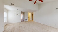 Located at Merchant's Square in Lancaster, PA, this well-designed 3-bedroom, 2-bathroom home offers a comfortable and functional layout across a single floor. The living room is a standout space, boasting soaring vaulted ceilings, a ceiling fan, and a classic chandelier that adds a touch of elegance. Plush neutral carpeting runs throughout the living areas and bedrooms, complementing the bright, airy atmosphere created by natural light filtering through window blinds. The kitchen features warm cherry-toned cabinetry, dark granite-style countertops, a breakfast bar peninsula, and black appliances including a refrigerator and range, all set over rich hardwood flooring. The primary bedroom is generously sized with vaulted ceilings, a ceiling fan, and a window overlooking the outdoors, accompanied by a spacious en-suite bathroom with dual-sink cherry wood vanity and tile flooring. The secondary bedrooms are well-proportioned with carpeted floors and natural light. A second full bathroom includes a tiled tub/shower combo and wood vanity. The home also includes two closets, a hallway, and a carpeted staircase with a wood handrail, completing this inviting Lancaster residence.