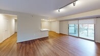 Located at 4001 Ninth St N in Arlington, Virginia, this single-floor residence offers a well-organized layout that balances open living spaces with private retreats. The kitchen is a standout feature, outfitted with white shaker-style cabinetry, white quartz countertops, a subway tile backsplash, and a full suite of stainless steel appliances including a refrigerator, range, microwave, and dishwasher. Warm hardwood-style flooring runs throughout the kitchen, which opens directly into a generously sized living area. The living space benefits from a sliding glass door that introduces natural light and provides access to an outdoor balcony, offering views of the surrounding urban landscape. Track lighting illuminates the living area effectively. The bedrooms feature plush carpeting, track lighting, and windows framing views of neighboring buildings and greenery, creating a comfortable and quietly urban atmosphere. A double-door closet provides practical storage. The bathroom is clean and functional, featuring a wide white vanity with an undermount sink, a large mirror with overhead lighting, and a walk-in shower stall with built-in corner shelving. The overall aesthetic is modern and neutral throughout.