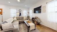 Located at 201 Telluride St in San Marcos, TX, this two-story, 2-bedroom, 3-bathroom home offers a well-organized layout spread across two floors. The main level features an open-concept living, dining, and kitchen area anchored by polished concrete floors and an abundance of natural light streaming through multiple windows dressed in sheer white curtains. The living room accommodates generous seating and flows seamlessly into the dining area and kitchen. The kitchen is outfitted with stainless steel appliances, gray shaker-style cabinetry, subway tile backsplash, a breakfast bar with pendant lighting, and direct access to a dedicated pantry. A convenient half or full bathroom is also found on the main floor. Upstairs, the two bedrooms are finished with light wood-look flooring and feature ample closet space. The primary bedroom offers comfortable proportions with multiple windows providing natural light. The upper level is served by well-appointed bathrooms, including one with a tub-shower combination and vanity with storage. Additional highlights include four closets, a laundry area, utility room, and two staircases connecting the floors, contributing to an efficient and functional floor plan throughout.